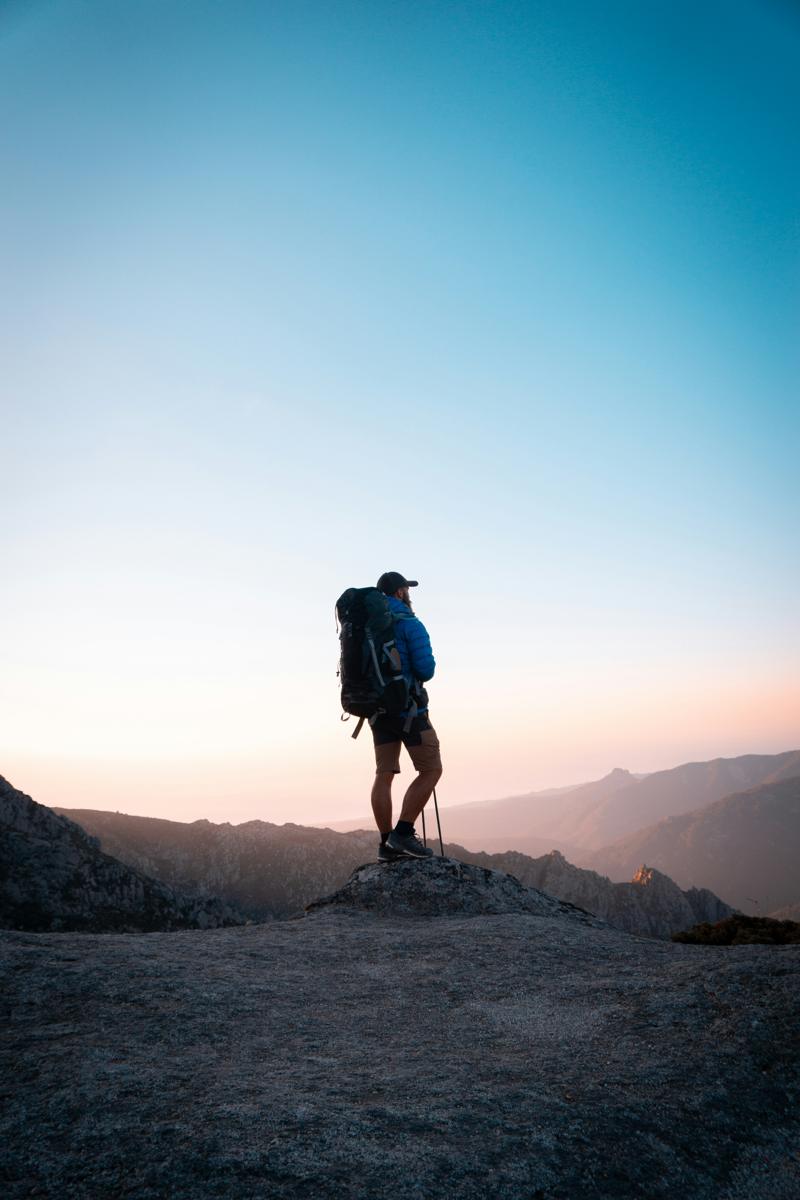 A hiker standing on a ridge at dawn